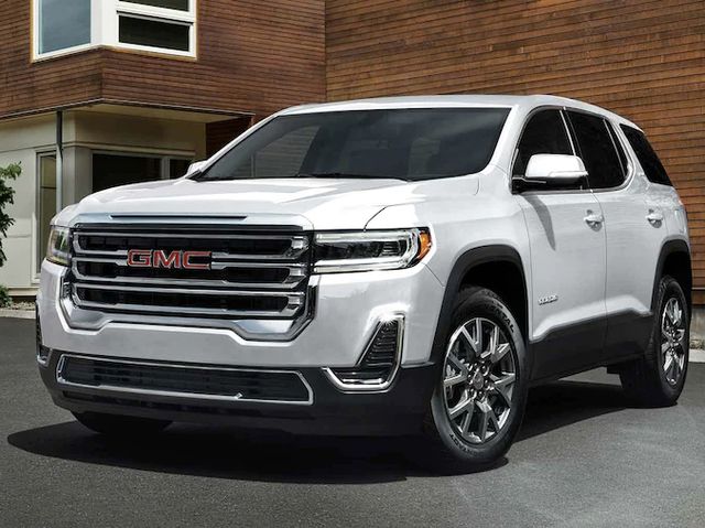 A white 2022 GMC Acadia parked in front of a house.