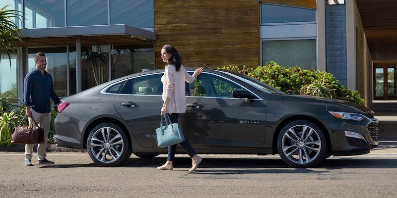 A woman getting into her 2023 Chevrolet Malibu.