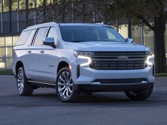 New 2024 white Chevy Suburban parked on the streets of Oxford, NC with a building in the background