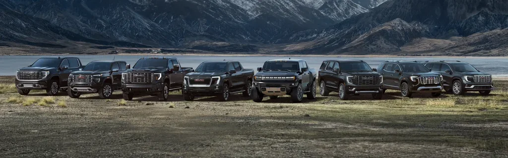 GMC vehicle lineup in a rugged outdoor setting.