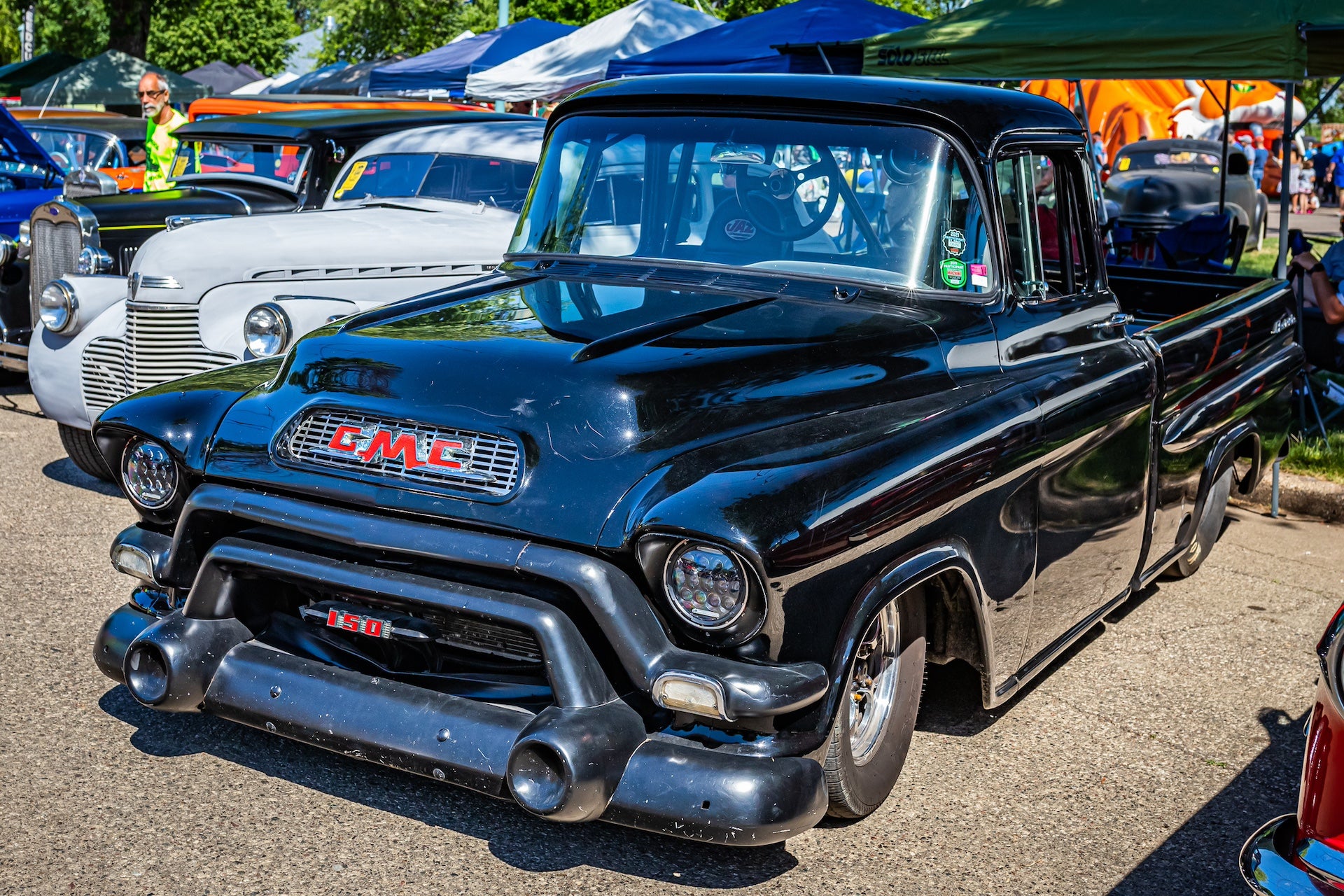 High perspective front corner view of a 1956 GMC 150 Suburban Pickup Truck at a local car show.