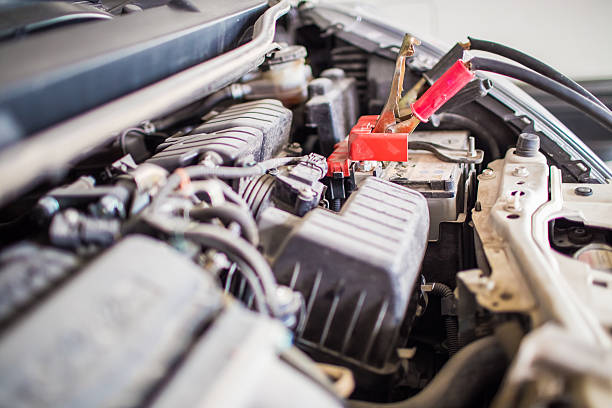 Jumper cables connected to car battery for recharging