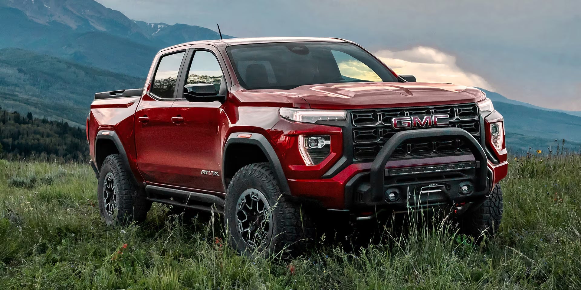 red 2025 GMC Canyon on a wild grassy field