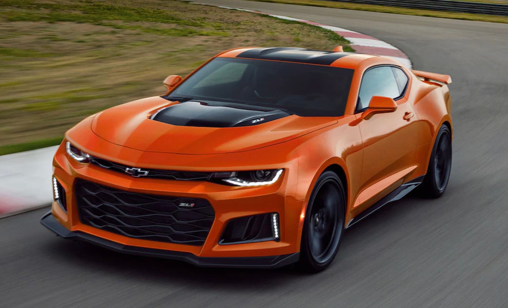 2022 Chevrolet Camaro driving quickly down a race track on a cloudy day.