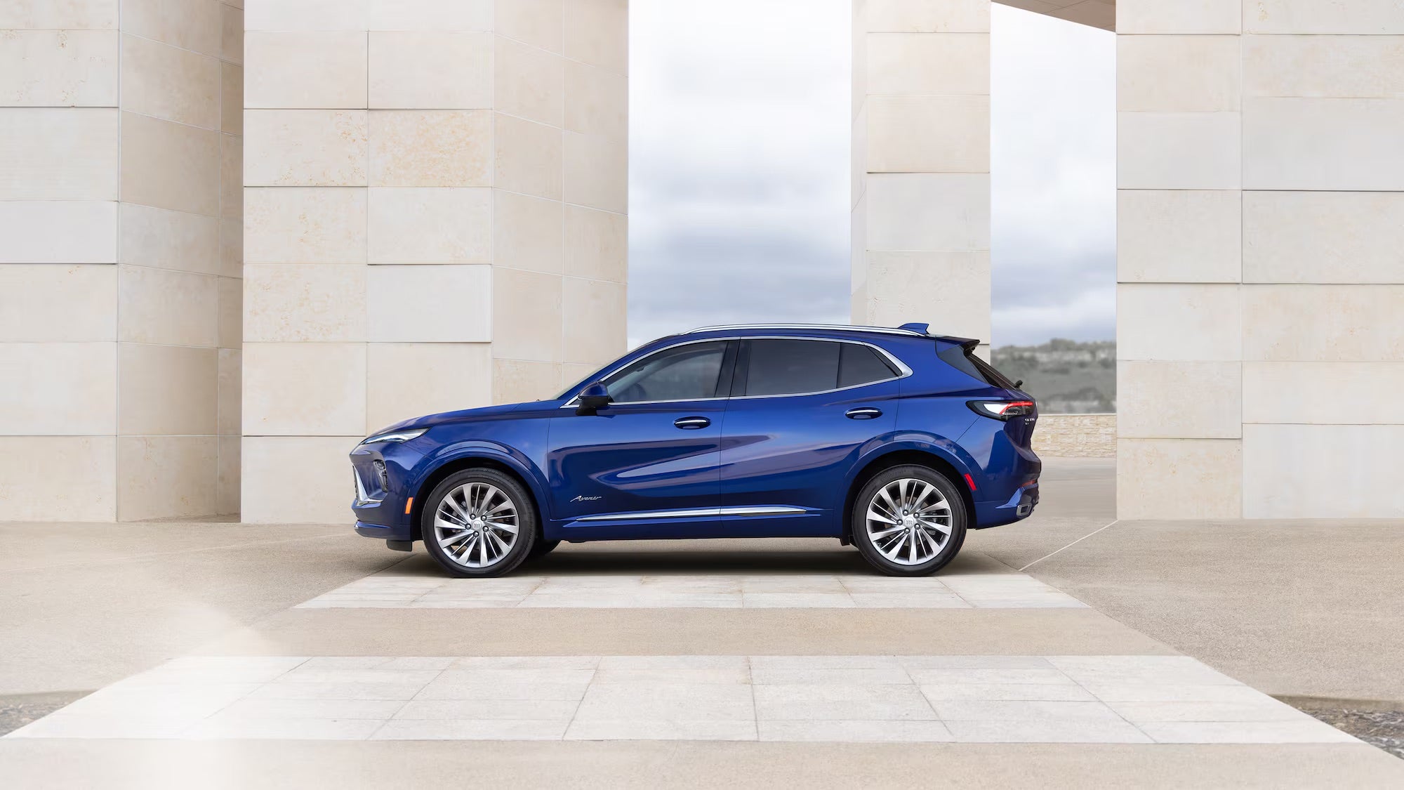 A blue 2025 Buick Envision parked outside building in Rockford, IL