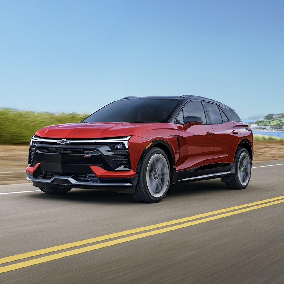 A 2026 Chevrolet Blazer EV Driving on a Highway Under a Clear Blue Sky.