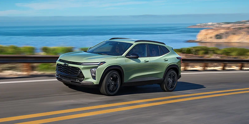 A green 2026 Chevrolet Trax driving down the road.