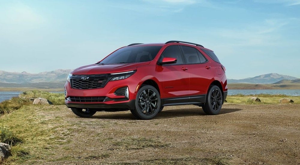 Red 2024 Chevy Equinox RS parked near a lake after leaving a Chevy dealer