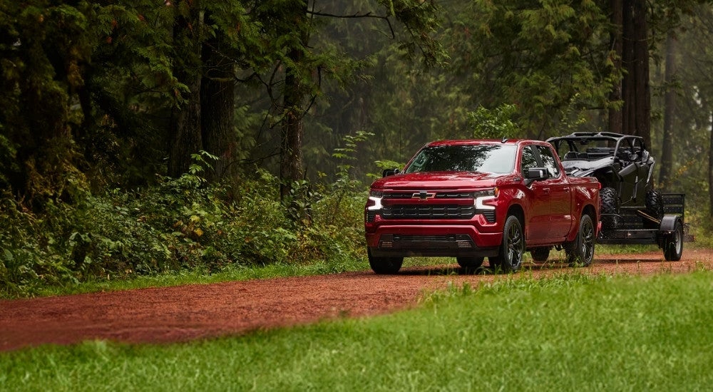 Red 2024 Chevy Silverado 1500 RST towing an ATV