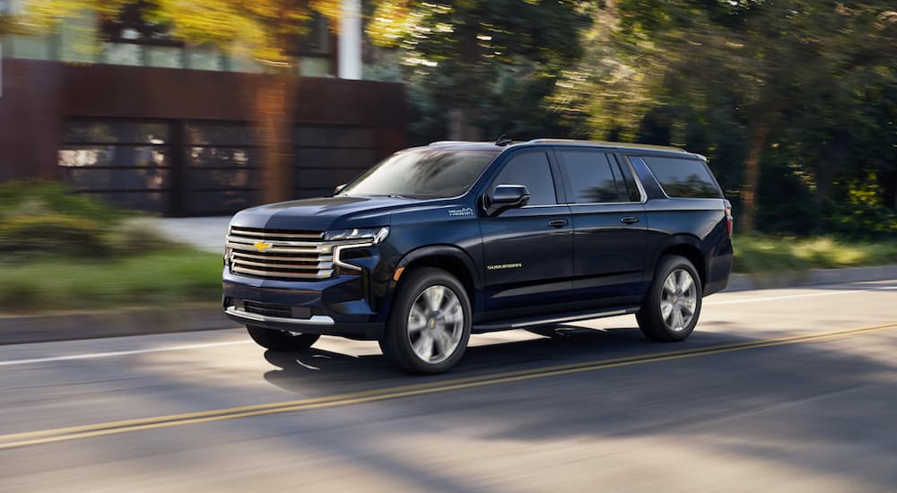 Blue 2021 Chevy Suburban High Country driving through a neighborhood
