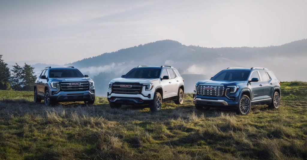 Three 2026 GMC Terrain SUVs parked on a grassy hill