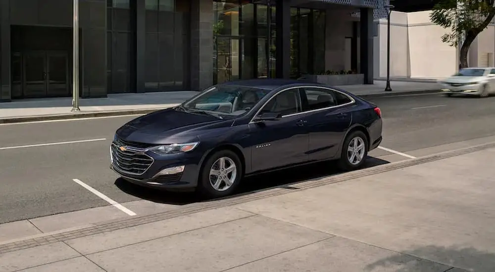 A dark blue 2022 Chevy Malibu is shown after leaving a certified pre-owned Chevy dealer.