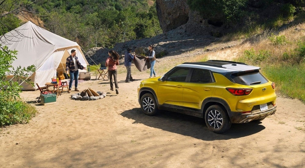 A yellow 2025 Chevy Trailblazer ACTIV is shown parked on a campsite.