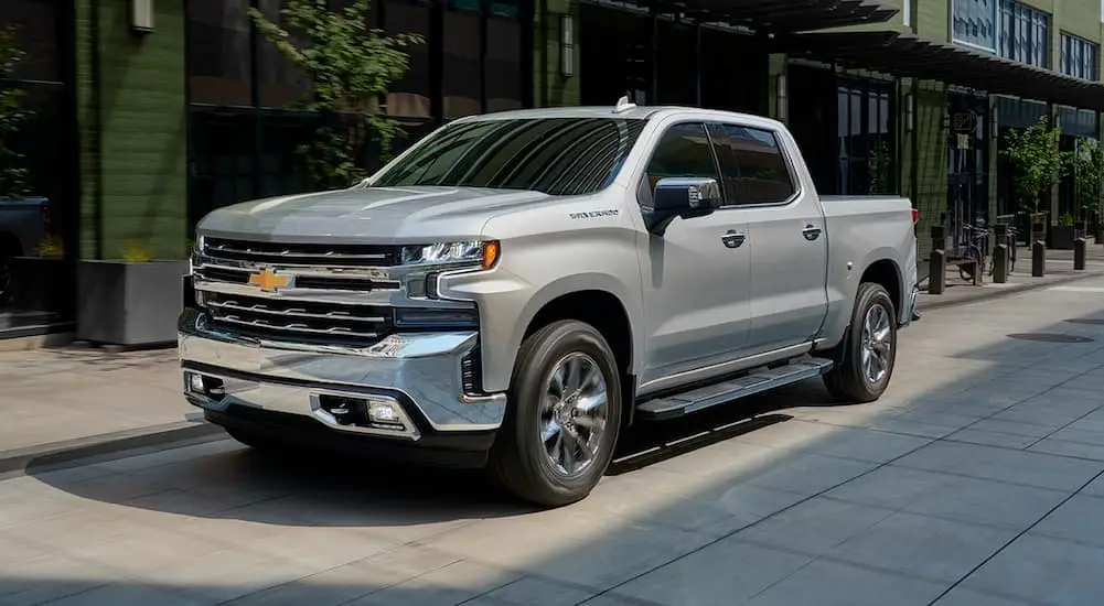A silver 2019 Chevy Silverado is shown on a street after leaving a used Chevy truck dealership.