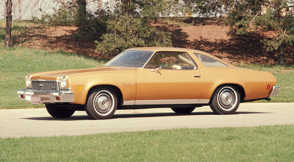 An orange 1973 Chevy Malibu is shown from the side.