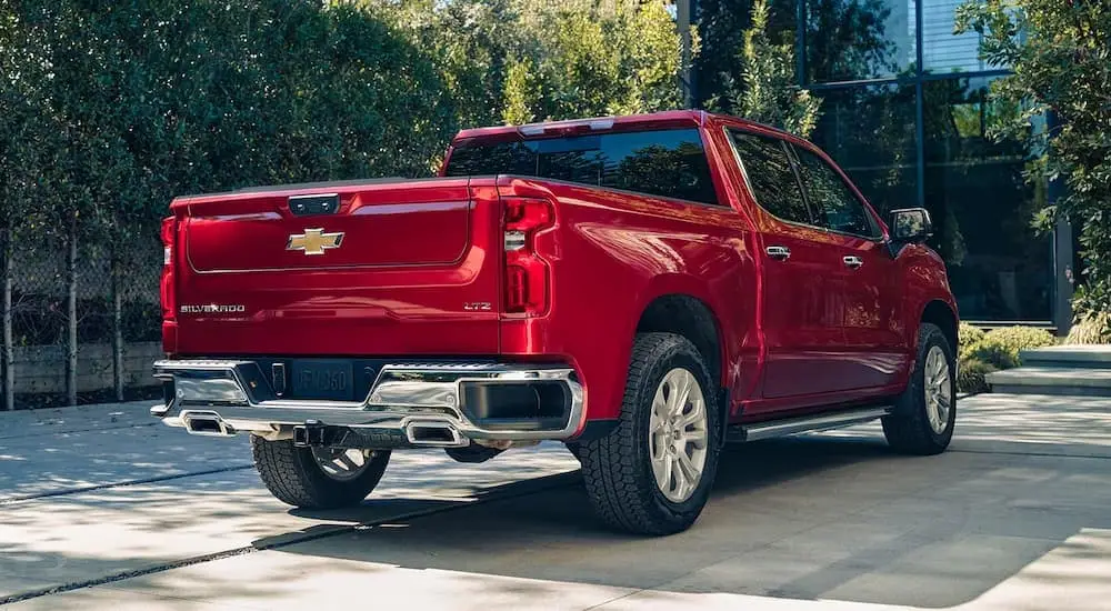 A red 2024 Chevy Silverado 1500 LTZ is shown from the rear parked on a driveway.