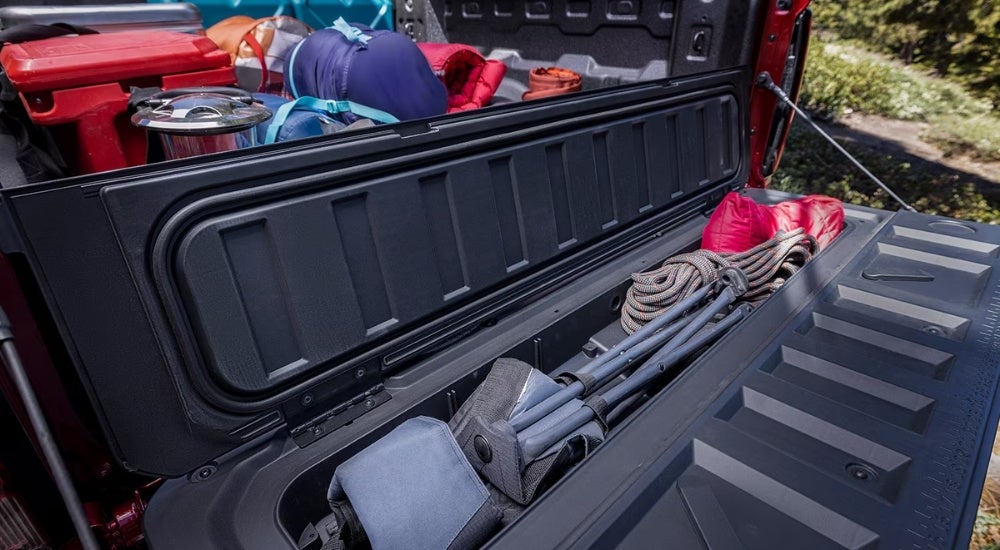 Gear is shown in the rear of a popular Chevy for sale, a red 2024 Chevy Colorado.