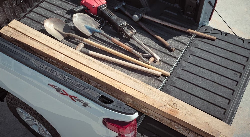 Tools are shown in the bed of a white 2024 Chevy Silverado 1500 WT.