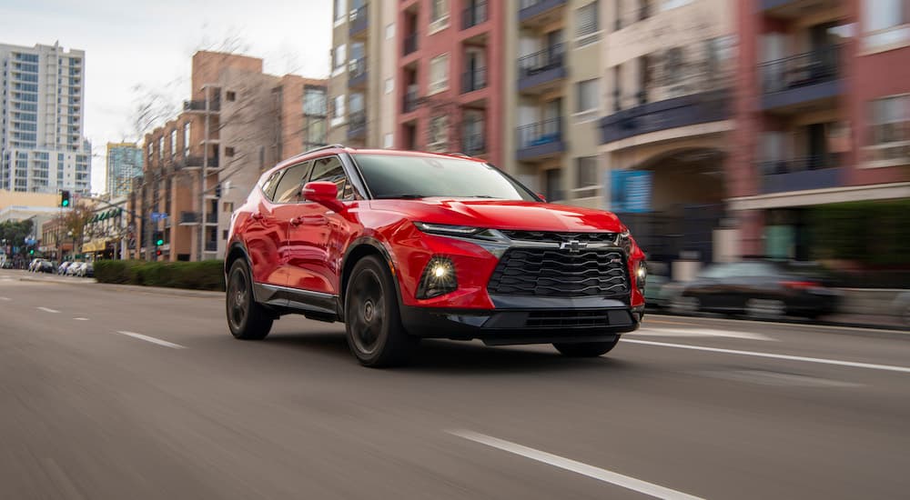A red 2019 Chevy Blazer RS is shown driving on a city street.