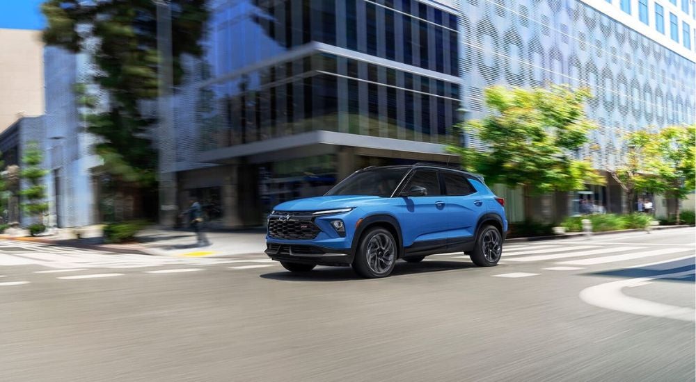 A blue 2025 Chevy Trailblazer RS driving in a city intersection from a Chevy dealer near Savannah.