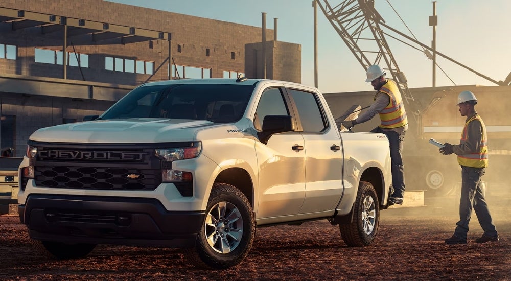 A white 2024 Chevy Silverado 1500 WT is shown on a construction site.
