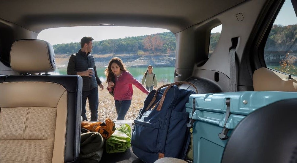 A family at a lake loading gear into the back of their 2024 Chevy Equinox.
