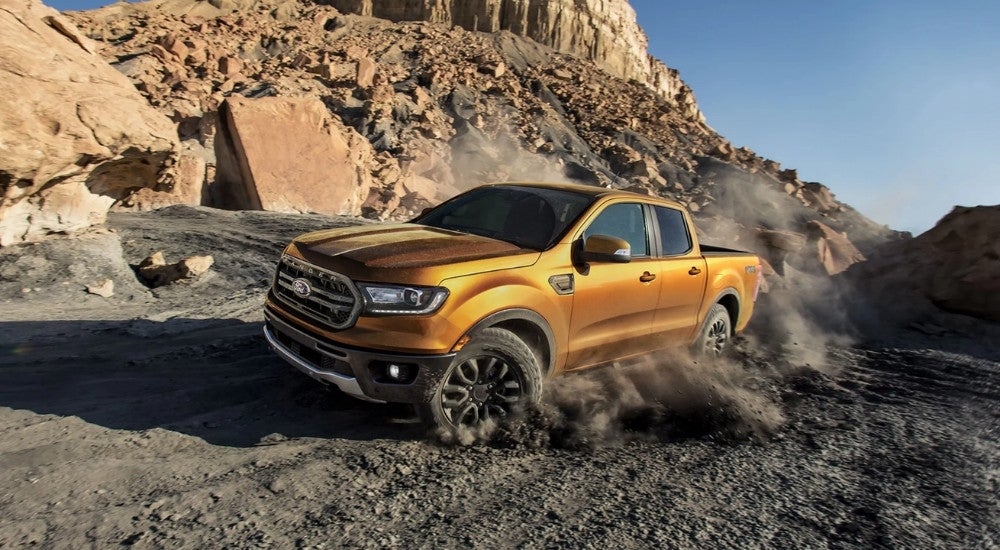 A gold 2021 Ford Ranger FX4 is shown off-roading in a desert area.