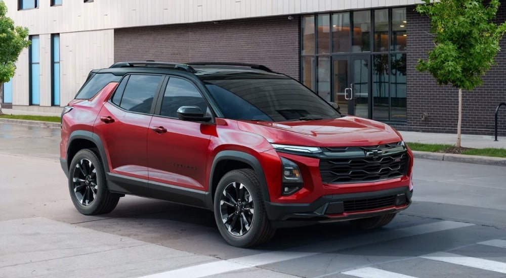 A popular Chevy for sale near Booneville, a red 2025 Chevy Equinox RS, is shown at a crosswalk.