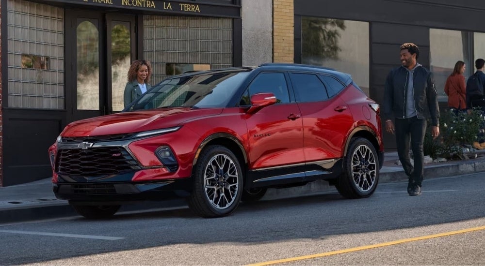People are shown walking toward a red 2023 Chevy Blazer RS.