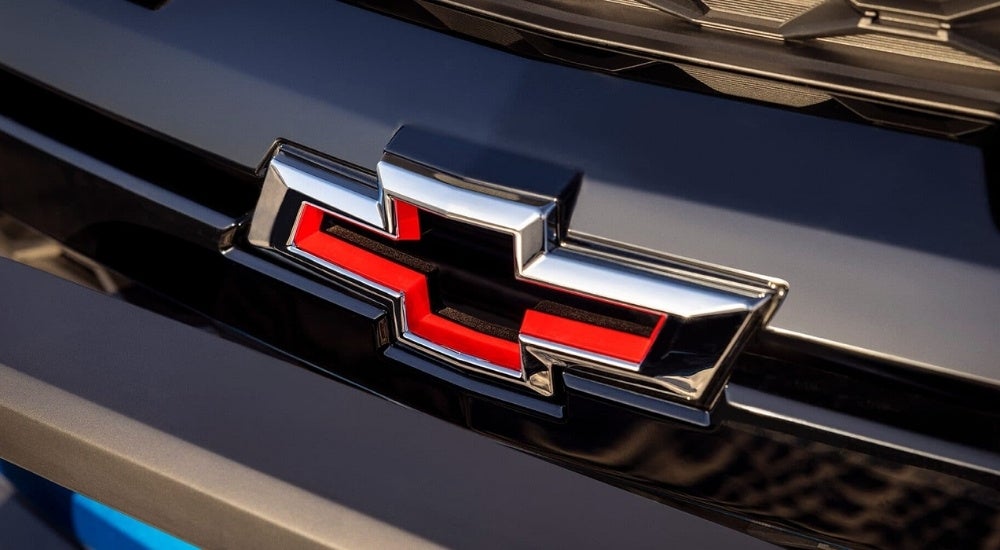 A close up shows the 'bowtie' badge on a blue 2023 Chevy Colorado ZR2.