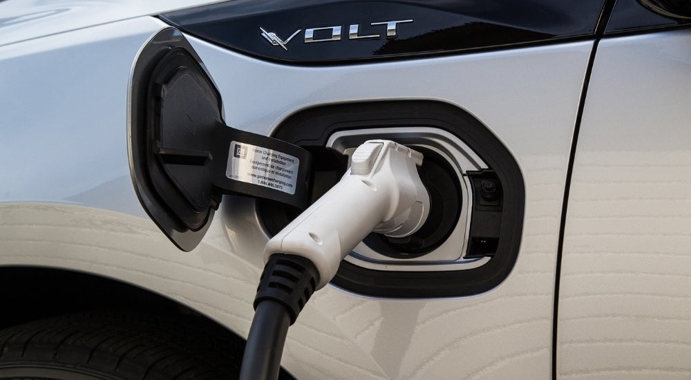 A close-up shows a silver 2016 Chevy Volt charging.
