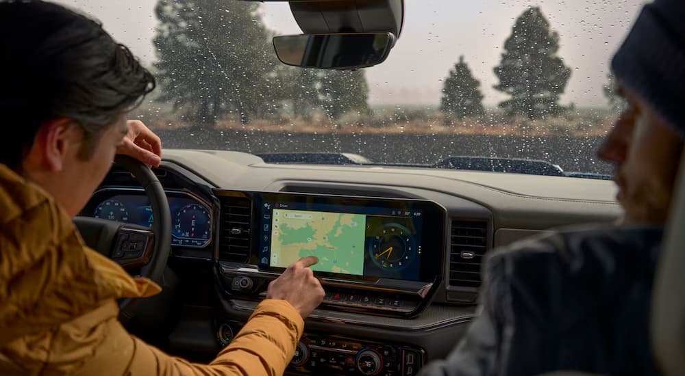A person is using the map on the infotainment screen in a 2025 Chevy Silverado 1500.