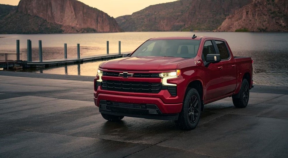 A red 2023 Chevy Silverado 1500 Z71 is shown from the front parked by a lake.