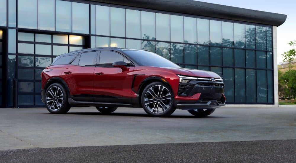 A red 2024 Chevy Blazer EV SS is shown parked outside a modern building.