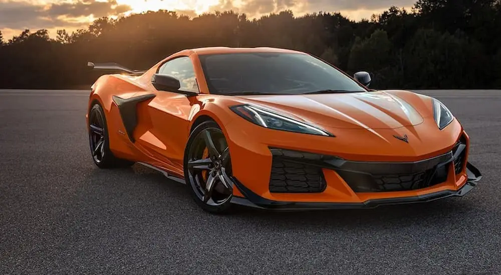 An orange 2022 Chevy Corvette Z06 is shown parked in large empty lot.