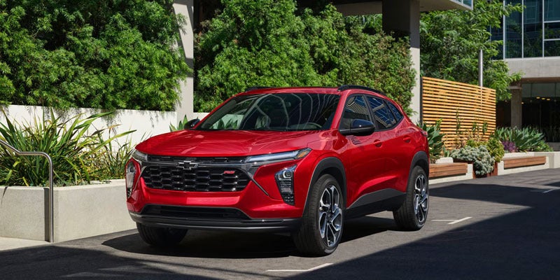 Front three-quarter view of a red Chevrolet Trax RS parked outdoors in an urban setting.