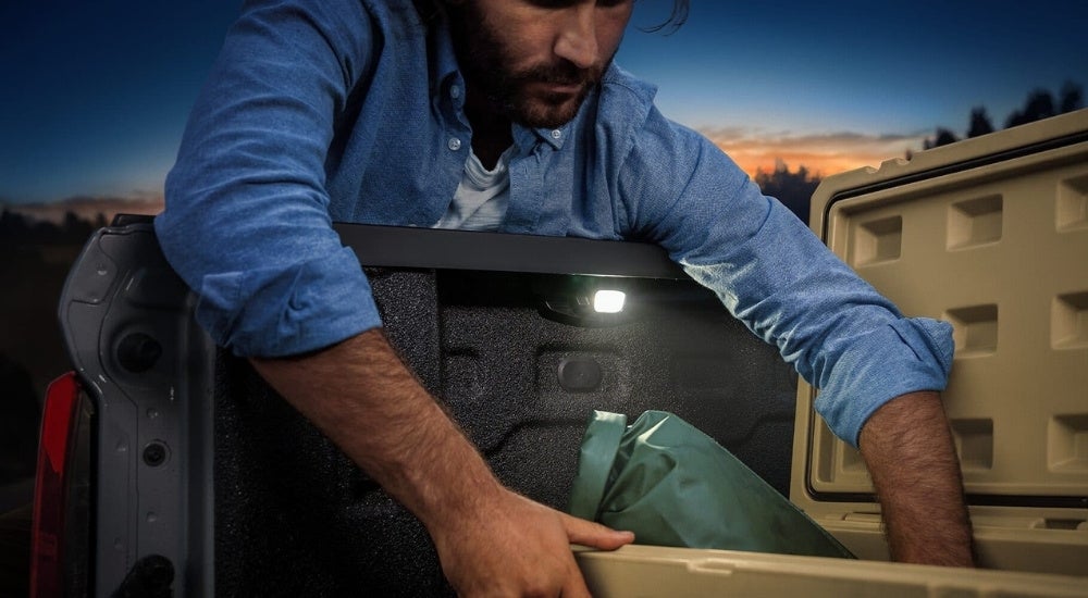 A bed light is shown on a grey 2023 Chevy Colorado.