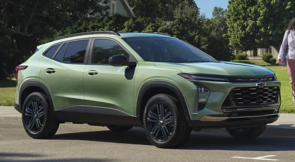 A green 2026 Chevy Trax ACTIV parked near grass.