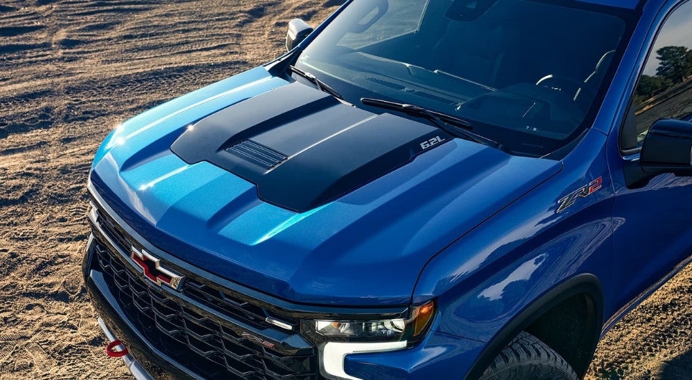 A close-up shows the hood on a blue 2025 Chevy Silverado 1500 ZR2.