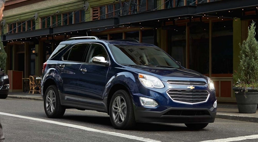 A blue 2016 Chevy Equinox is in front of a restaurant.