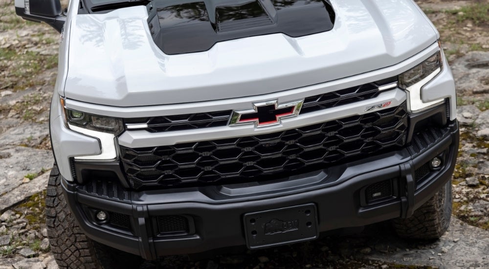 A close-up shows the front of a white 2025 Chevy Silverado 1500 ZR2 Bison.