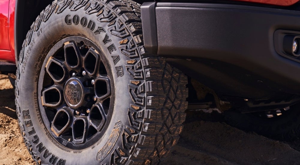 A black wheel is shown on a red 2024 Chevy Silverado 2500 HD ZR2 Bison.