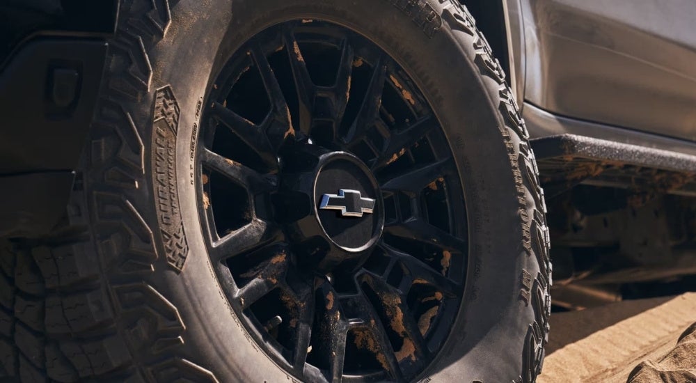 A close-up shows a black wheel on a grey 2025 Chevy Silverado 2500 HD.