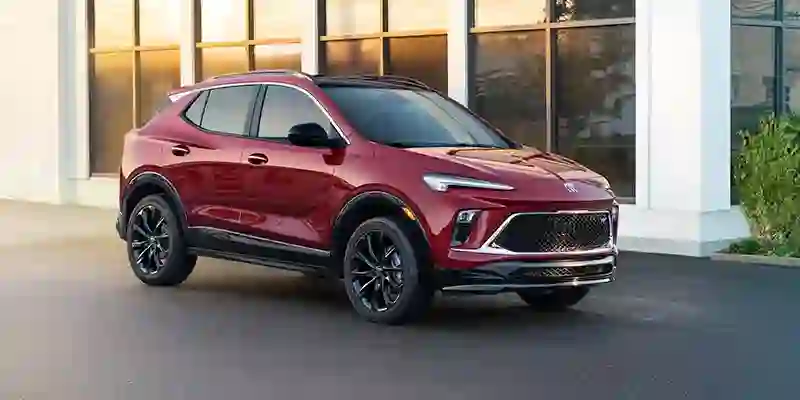 Red Buick SUV parked in front of a modern building.