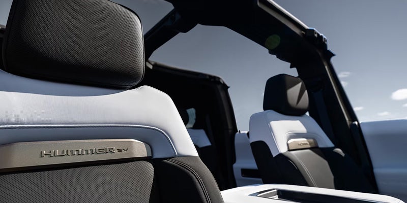 Interior seats of a 2025 GMC HUMMER EV SUV, featuring black and white leather with Hummer EV branding.