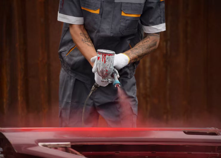 front-view-worker-spraying-powder-paint-from-gum_52683-97009