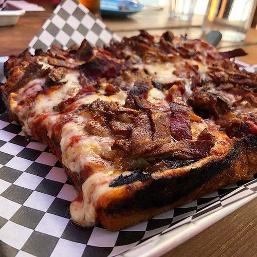 Detroit-style pizza with meat at low angle