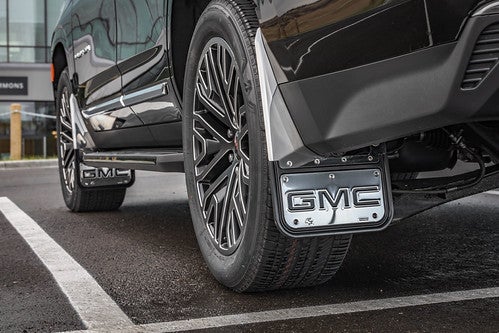 Low angle on black 2021 GMC Sierra 1500 rear left wheel with GMC logo on a tire flap