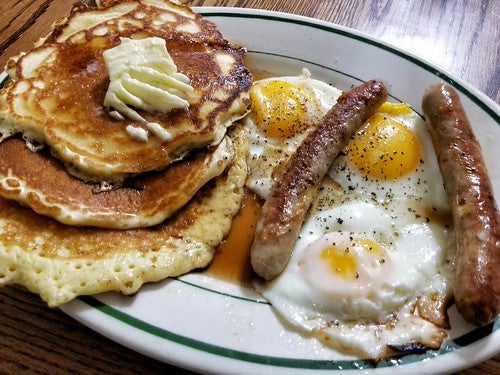 A diner breakfast of sausages, eggs, and pancakes
