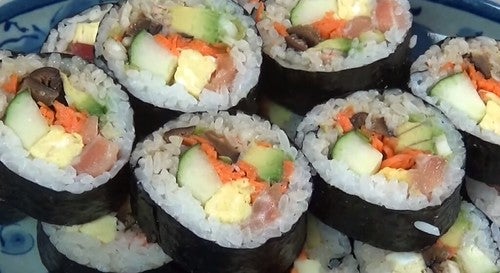 Close up picture of sushi rolls with vegetables, and some fish